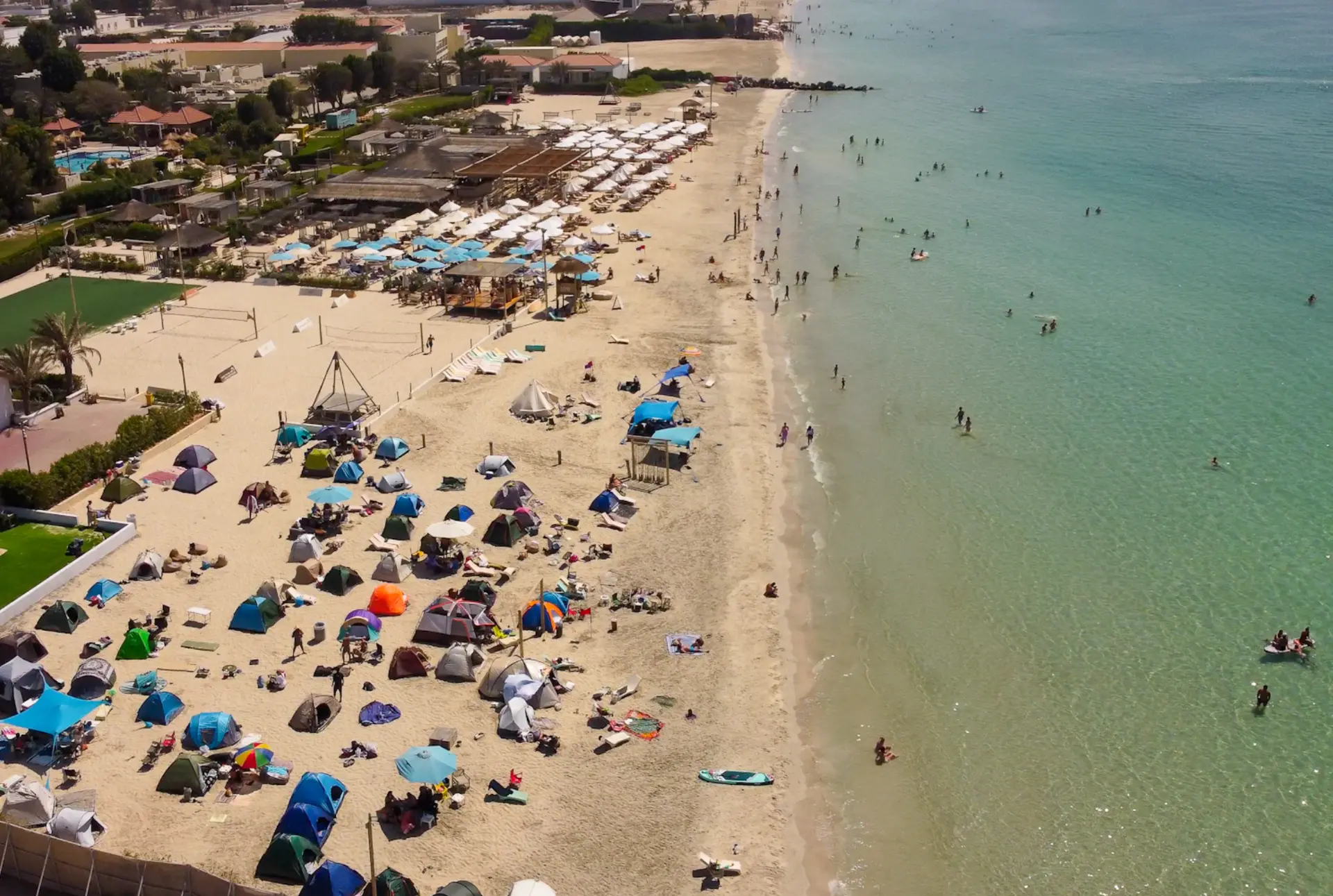Aerial view of tents pitched along the sand at Lumi Beach