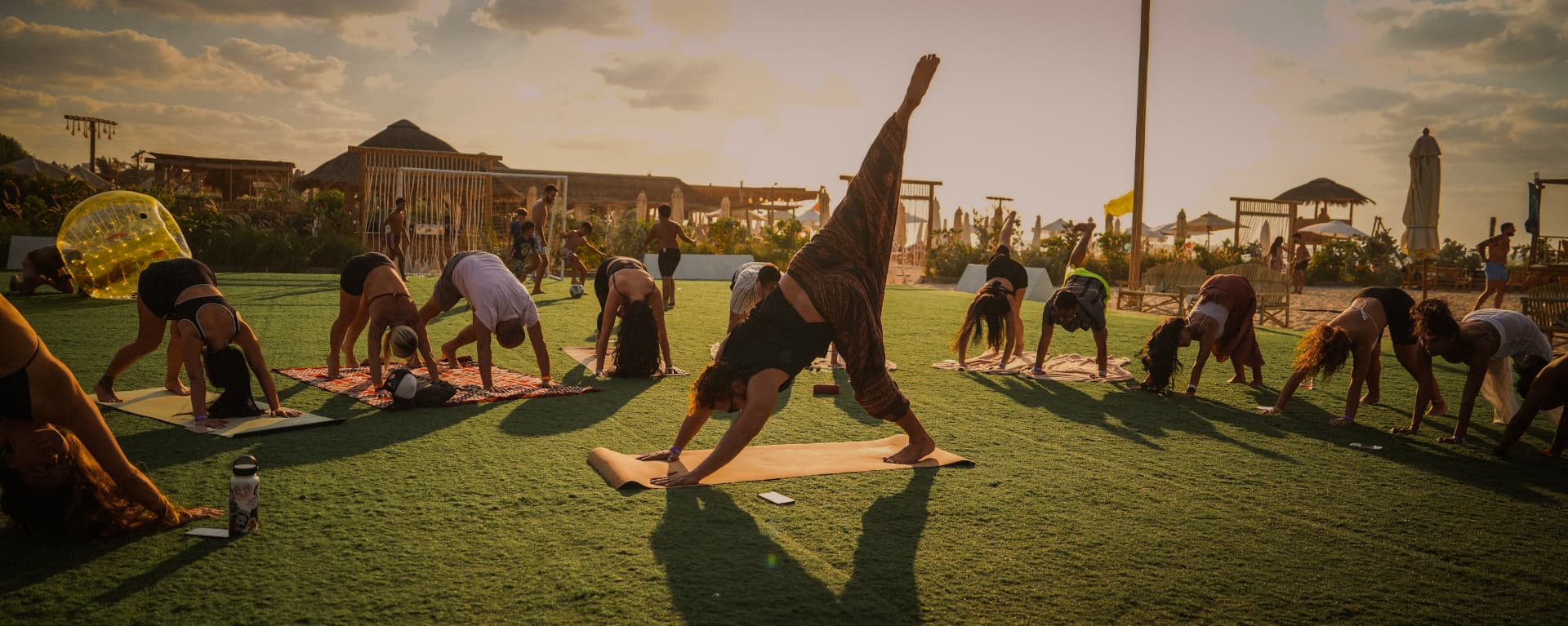 A sunset yoga class on the grass at Lumi Beach